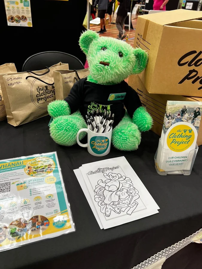The Clothing Project display with a green teddy bear